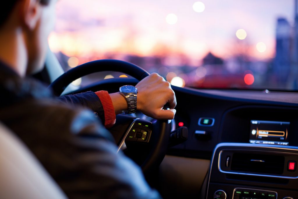 un homme conduisant une voiture de marque Nissan la nuit